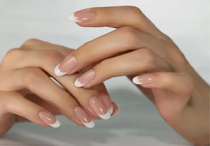 Dłonie z klasycznym manicure francuskim.