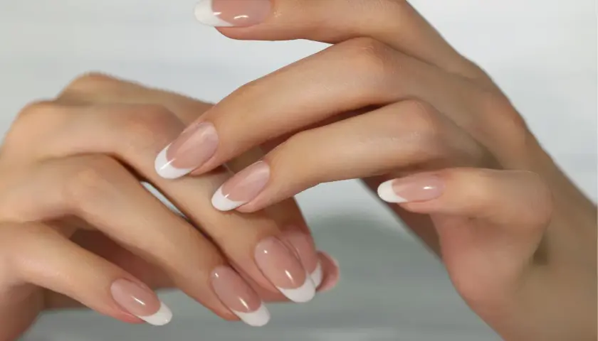 Dłonie z klasycznym manicure francuskim.